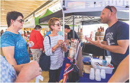 A representative from Twisted X Brewery in Dripping Springs shares his passion with visitors at the first Fredericksburg Craft Beer Festival. – Photo by Robynn Dodd