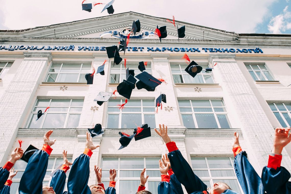 College Fair Extravaganza group of fresh graduates students throwing their academic hat in the air