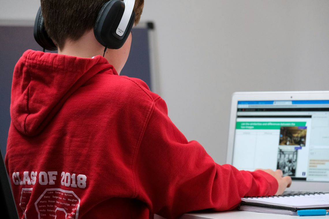 Can Free Video Lessons Replace Expensive Tutoring boy in red hoodie wearing black headphones