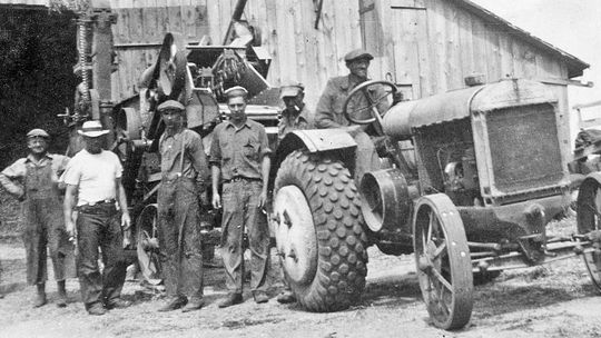 Here’s a thrashing crew at Art &amp; Laura Basch’s farm, using Henry &amp; Ernie Anderson’s thrashing machine. That’s Ernie on the tractor, and his brother Henry three men to the left. Preserve Historic Sleeping Bear Online Archive