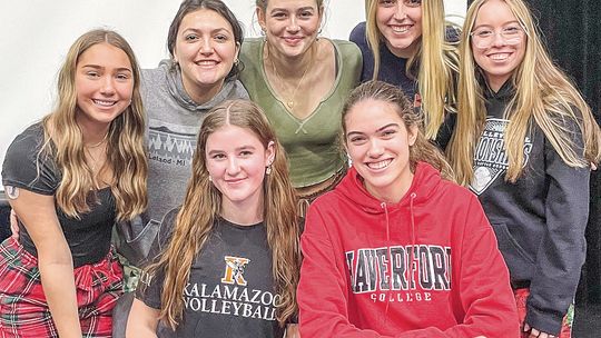 Leland seniors Olive Ryder (center-left) and Fiona Moord (center-right) are joined by their Comet teammates as they committed to play volleyball at the collegiate level. Enterprise photo by Brian Freiberger