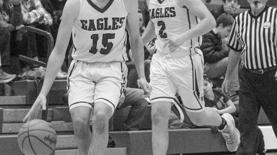 Lake Leelanau St. Mary sophomore Oliver Mitchell dribbles up the court during a home game against Grand Traverse Academy on Tuesday while Eagle senior Jerry Schaub hustles up the floor. Enterprise photo by Brian Freiberger