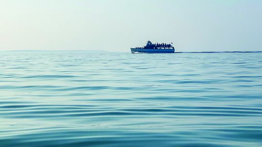 Beach-goers at Good Harbor Bay spotted the Mishe-Mokwa cruising the smooth waters during a sunset cruise on Sunday. Enterprise photo by Brian Freiberger