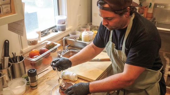 Iconic chef Justin Tootla prepares a ‘Leelanau burger’ at Gilchrist Farm in Suttons Bay. Enterprise photo by Brian Freiberger