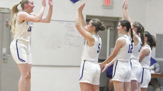 Lake Leelanau St. Mary senior Leah Fleis jumps to give her teammates high-five’s before beating Kalkaska on Friday night. Enterprise photo by Brian Freiberger