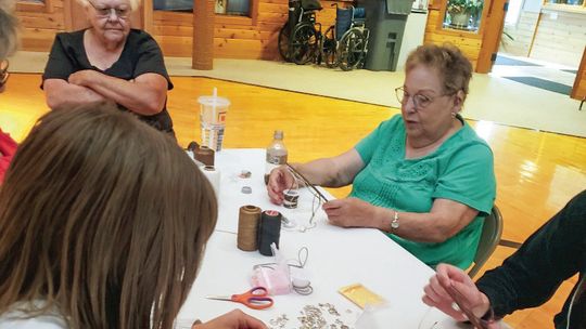 Workshop participants are pictured putting together dream catchers during one of the many Heritage Library activity sessions led by tribal librarian Francis Carew and his mother, Roseanne Raphael. Courtesy photo