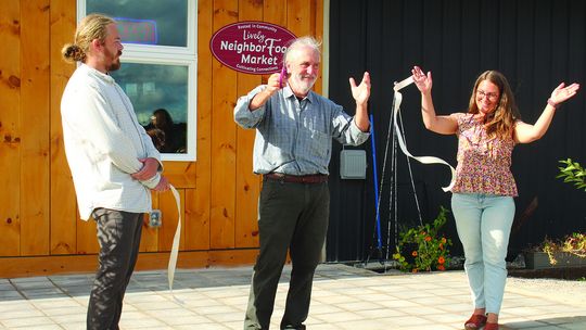 Jim Lively cuts the ribbon of the official opening of The Lively NeighborFood Marker on M-72, right before you get to Empire. Enterprise photo by Brian Freiberger