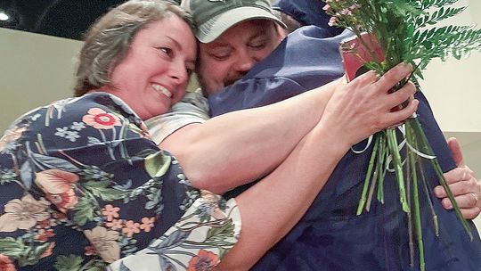 Northport Public School senior Dashel Courson embraces family members during the presentation of the parent flower ceremony at Friday’s graduation.