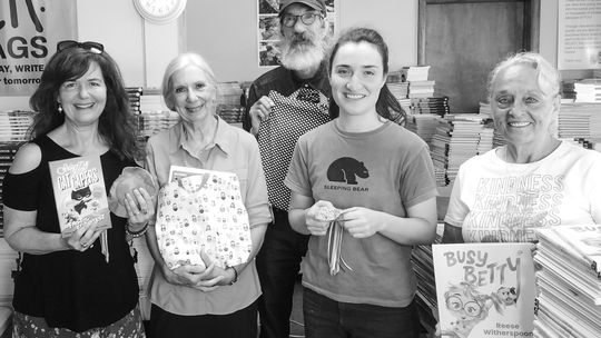 Kara Gregory stands on the far left inside the PoWeR! Book Bags office in Suttons Bay alongside volunteers and the organization’s one employee, Gabrielle David, second from right. The three volunteers, from left, are Lucy Crandell, Guy Plamondon, and Gloria Dean. Enterprise photo by Zachar...