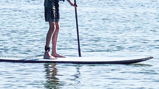 Warmer temperatures hasten water activities. This lone paddleboarder braved the water on Fisher Lake near Glen Arbor. Enterprise photo by Amy Hubbell