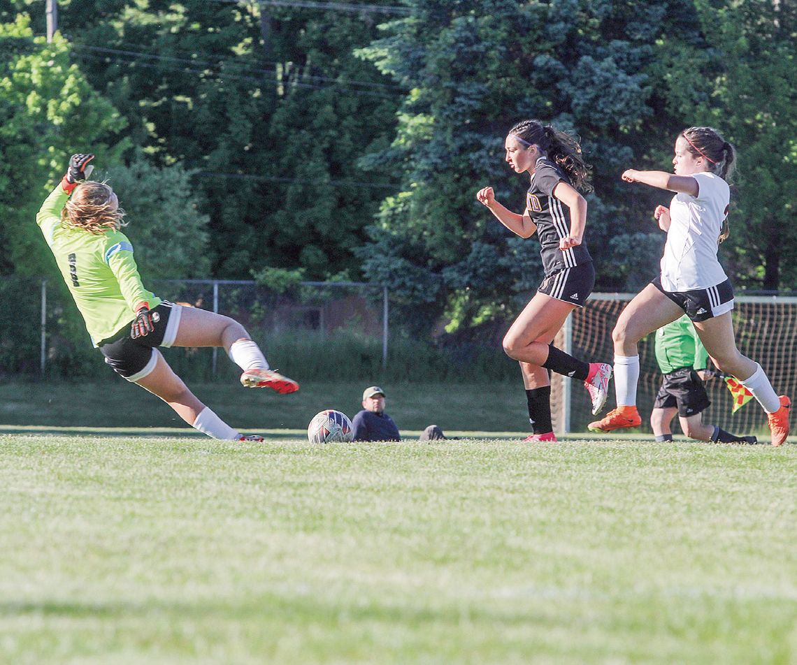 Leland freshman Lillian Connor dashes past a defender to score a goal during a district championship game against Elk Rapids. Enterprise photo by Brian Freiberger