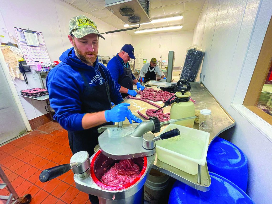 Roger Mikowski (left), Donald Jackson (middle), and Lennie Mikowski (right) of Mikowski’s Meat &amp; Deli cut up fresh meat for purchase at Hansen Foods in Suttons Bay every Thursday. The two local companies announced a partnership with a community cookout planned for August 16 from noon t...