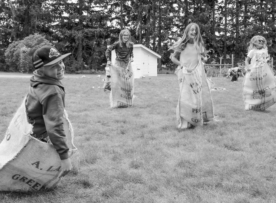 Kids enjoy a “good old fashioned” burlap sack race at the Olsen farm. Family games are just one of the many interactive and hands-on activities at the Port Oneida Fair, Aug. 10 and 11. Photo courtesy of the National Park Service.