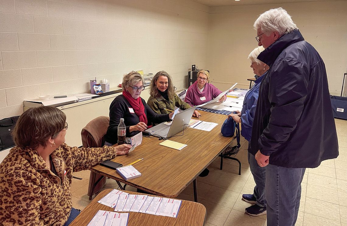 Election workers stationed at Suttons Bay Public School are pictured helping people check in before they get their ballots on Tuesday evening. Enterprise photo by Meakalia Previch-Liu