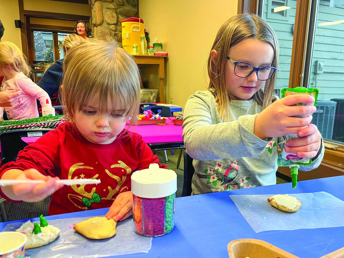 Madison and Savannah Potes, from left, are shown decorating cookies at a recent Parenting Communities event. The girls are from Northport. Photo courtesy of Courtney Yaple