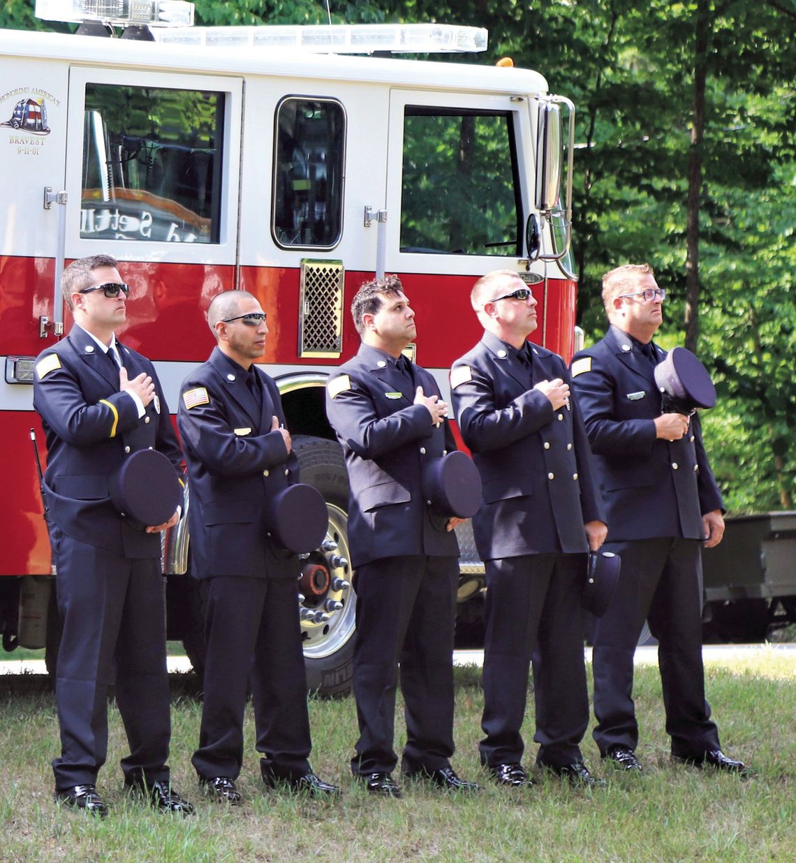 Members of the Glen Lake Fire Department salute the flag at last year’s flagraising ceremony organized by the Glen Lake Woman’s Club. Photo courtesy of Grace Dickinson Johnson