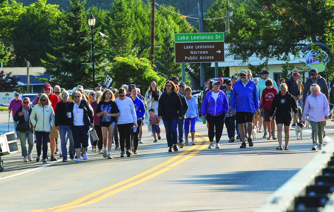 Nearly a hundred bridge walkers descended across the narrows bridge of Lake Leelanau to celebrate Labor Day. The walkers started at Pedaling Beans before walking across the bridge to Boathouse Vineyards for an exhilarating duck race on Monday. Enterprise photo by Brian Freiberger