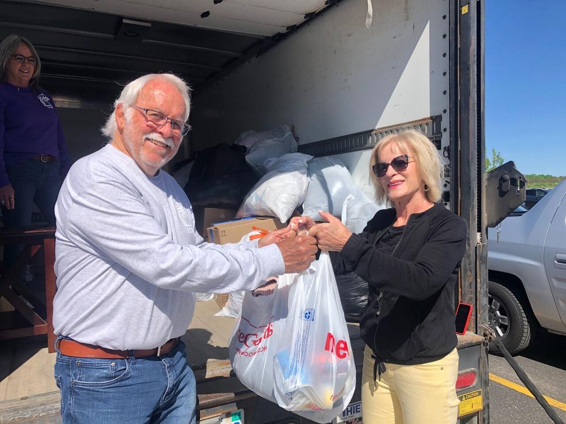 Nanette Walter of Suttons Bay Township dropped off bags of goods for Leelanau Christian Neighbors while attending service at West Side Community Church. Accepting the donation at the LCN panel truck is board member Steve Stanton. Enterprise photo by Alan Campbell
