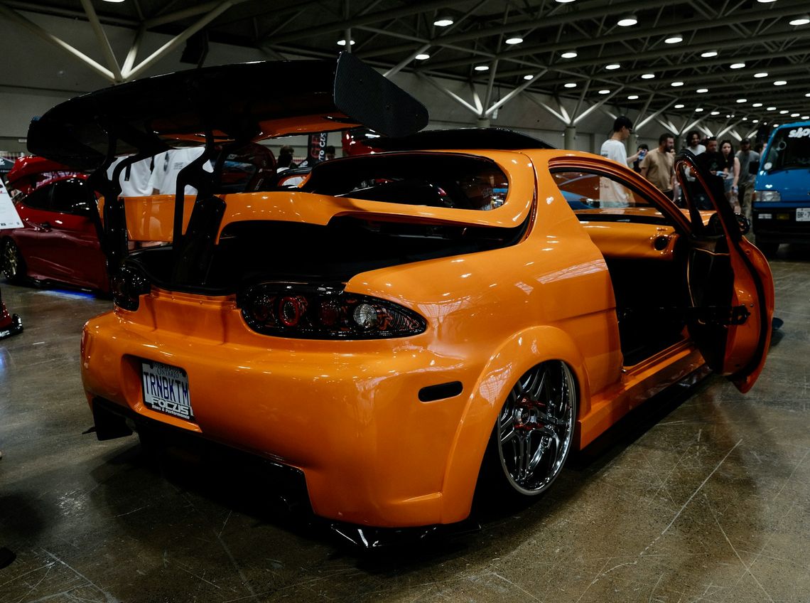Moto Show An orange car parked inside of a garage
