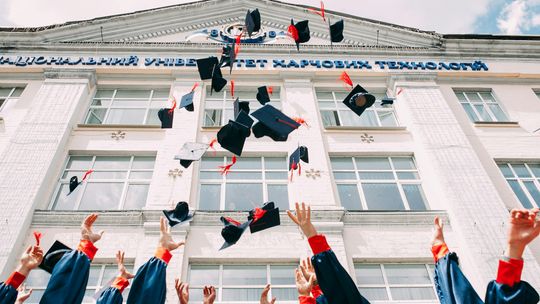 College Fair Extravaganza group of fresh graduates students throwing their academic hat in the air